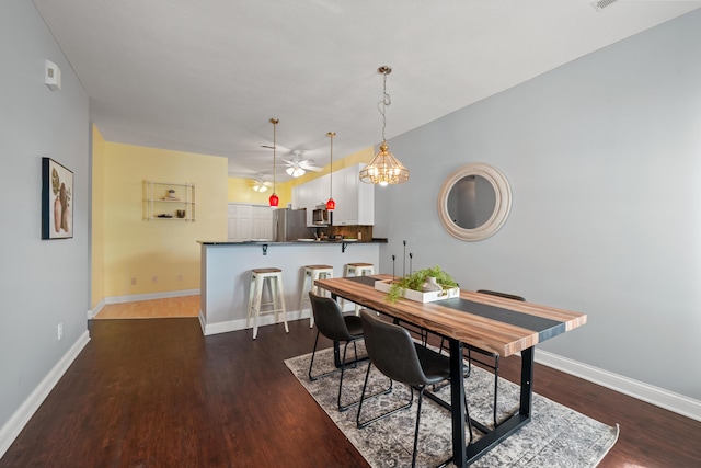 dining room with a ceiling fan, baseboards, and dark wood-style flooring