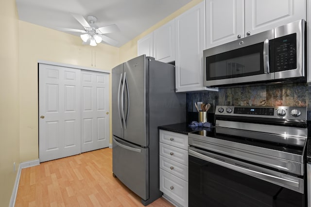 kitchen featuring backsplash, appliances with stainless steel finishes, light wood-style floors, a ceiling fan, and white cabinets