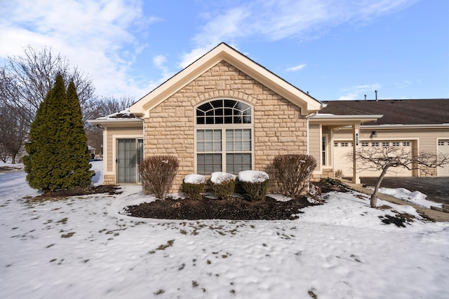 single story home with an attached garage and stone siding