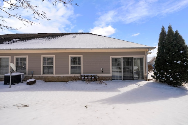 snow covered back of property with central air condition unit