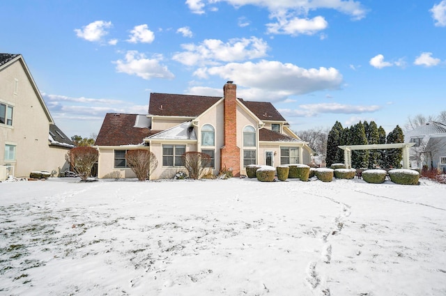 snow covered property with a chimney