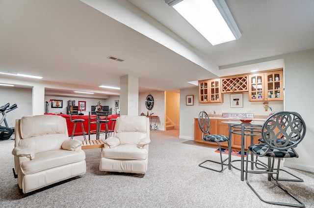 living room featuring light carpet, a bar, stairs, and baseboards