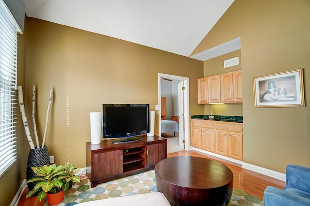 living area featuring visible vents, baseboards, and vaulted ceiling