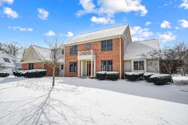 view of front of home featuring brick siding and a balcony