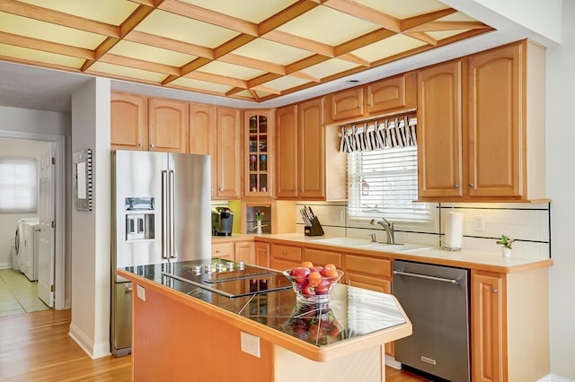 kitchen featuring a center island, separate washer and dryer, appliances with stainless steel finishes, coffered ceiling, and a sink