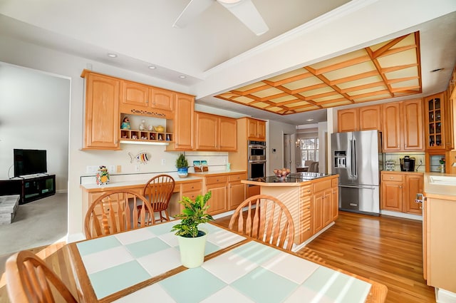 kitchen featuring backsplash, appliances with stainless steel finishes, a kitchen island, and coffered ceiling