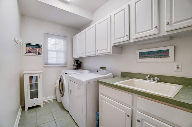 clothes washing area with visible vents, washer and clothes dryer, light tile patterned floors, cabinet space, and a sink