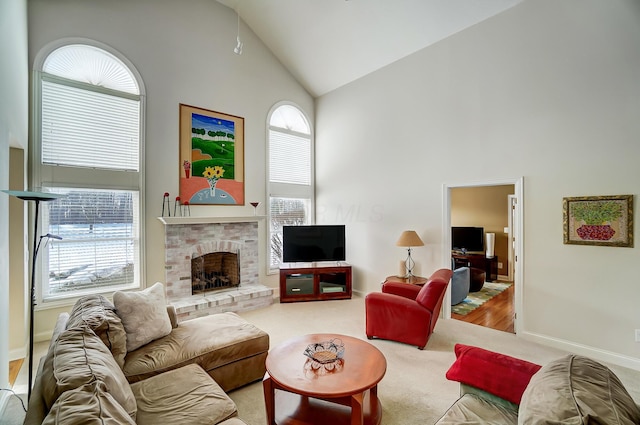 carpeted living area with baseboards, high vaulted ceiling, and a fireplace