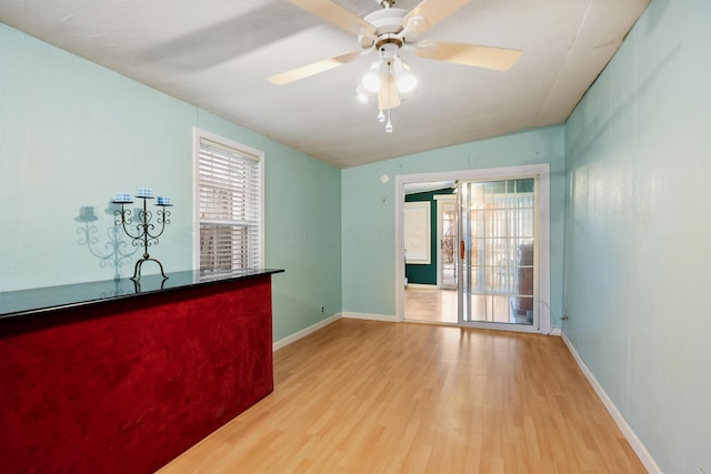 unfurnished room featuring ceiling fan, lofted ceiling, and light hardwood / wood-style flooring