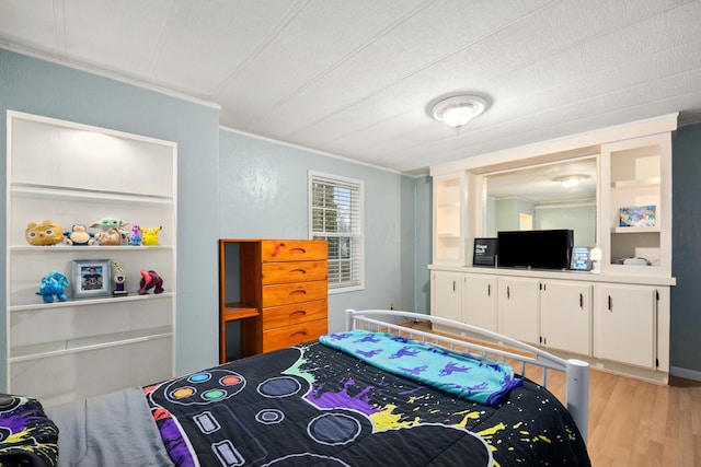 bedroom featuring crown molding and light hardwood / wood-style floors