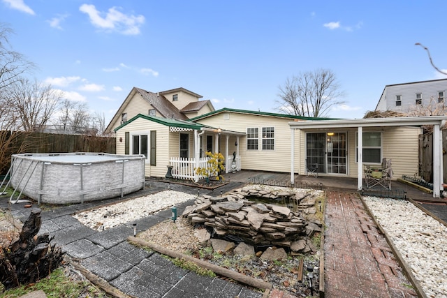 back of property featuring a fenced in pool