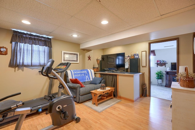 exercise area featuring recessed lighting, a drop ceiling, and light wood-type flooring