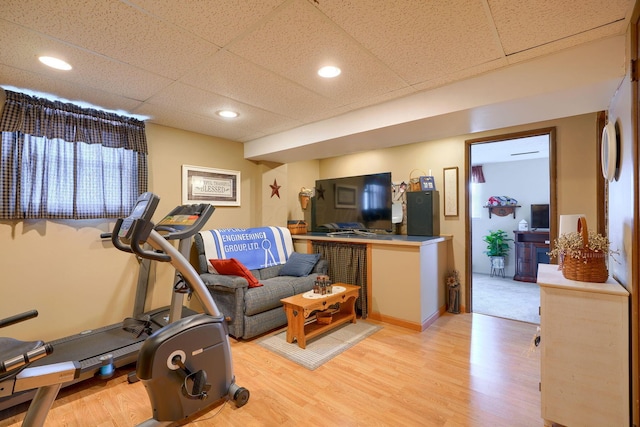 exercise area featuring a paneled ceiling and light wood finished floors