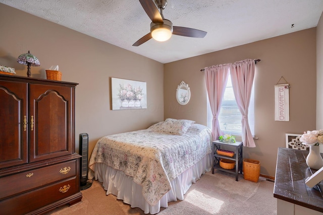 bedroom featuring a textured ceiling, ceiling fan, and light carpet