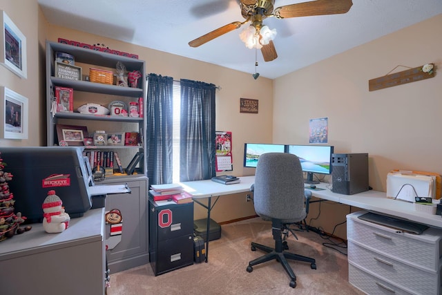 carpeted office with a ceiling fan