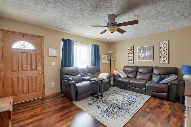 living room with dark wood-style flooring, ceiling fan, and a textured ceiling