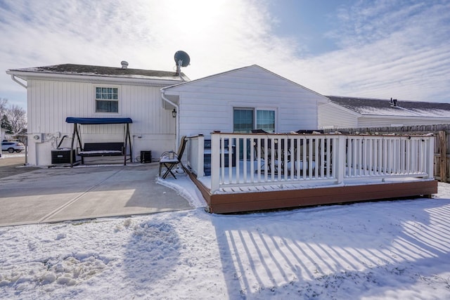 snow covered rear of property featuring a deck