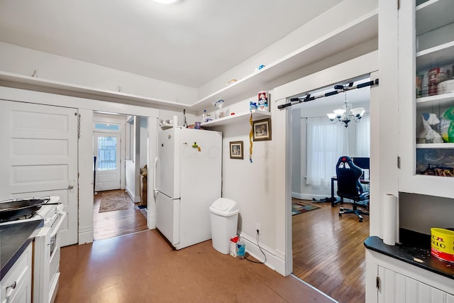 kitchen with dark hardwood / wood-style floors, white cabinetry, white refrigerator, hanging light fixtures, and a notable chandelier