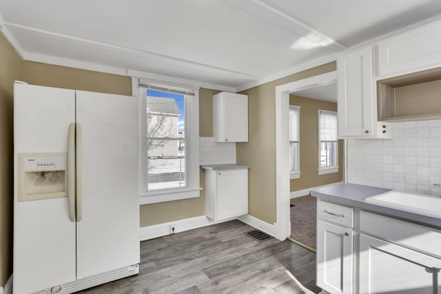 kitchen with light hardwood / wood-style flooring, white cabinets, decorative backsplash, sink, and white fridge with ice dispenser