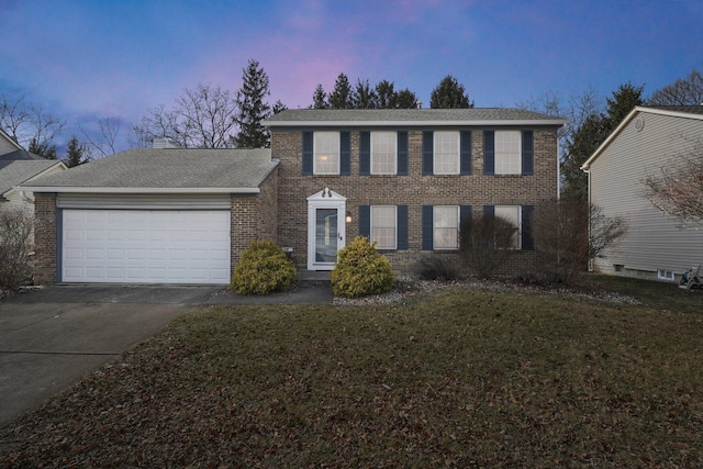 colonial house featuring a garage and a yard