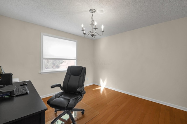 home office featuring wood-type flooring, a chandelier, and a textured ceiling