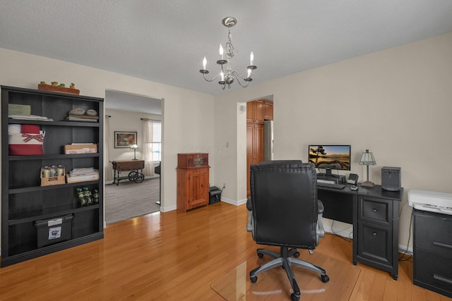 office area featuring an inviting chandelier, a textured ceiling, and light wood-type flooring