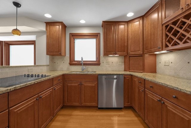 kitchen featuring sink, light stone counters, light hardwood / wood-style flooring, stainless steel dishwasher, and black electric stovetop