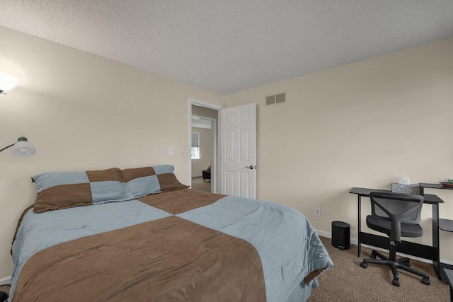 bedroom featuring carpet floors and a textured ceiling