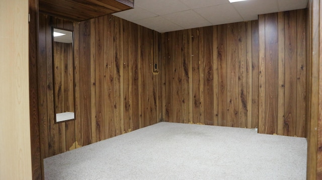 unfurnished room featuring wooden walls