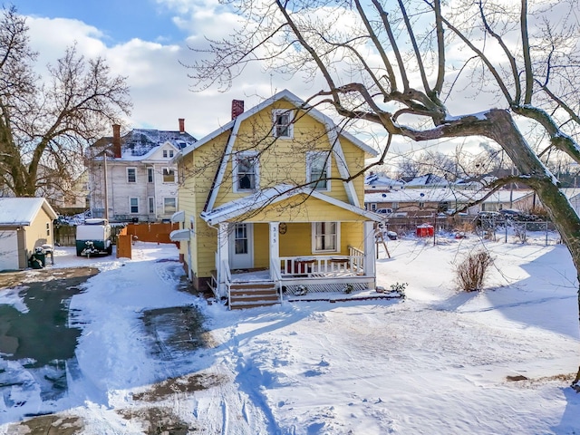 view of front of house featuring fence, covered porch, and a gambrel roof