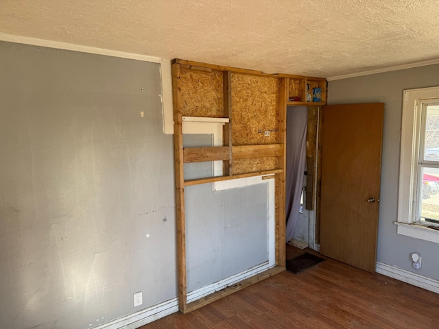 unfurnished room with wood-type flooring, a textured ceiling, and ornamental molding