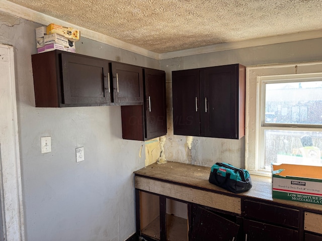 kitchen featuring dark brown cabinetry and a textured ceiling