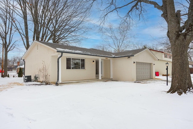 view of front facade with a garage, cooling unit, and stucco siding