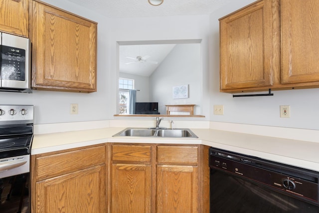 kitchen with ceiling fan, stainless steel appliances, a sink, vaulted ceiling, and light countertops