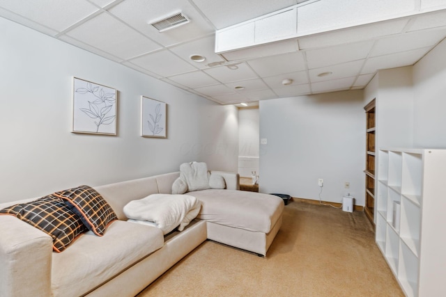 living room featuring a paneled ceiling, visible vents, light carpet, and baseboards