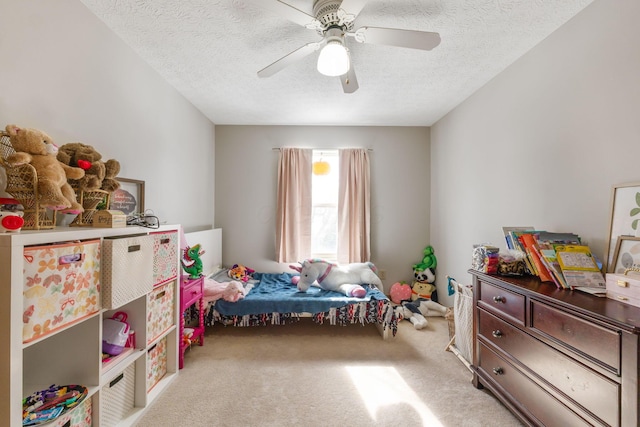 bedroom featuring a textured ceiling, a ceiling fan, and light colored carpet