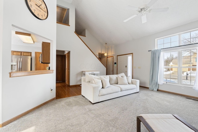 living room featuring baseboards, high vaulted ceiling, and light colored carpet