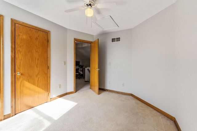 unfurnished bedroom featuring a ceiling fan, visible vents, light carpet, and baseboards