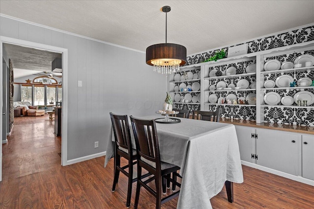 dining room with ceiling fan with notable chandelier, a textured ceiling, crown molding, and wood finished floors