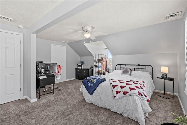 carpeted bedroom with visible vents, a textured ceiling, baseboards, and vaulted ceiling