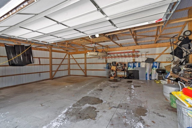 garage featuring a garage door opener and metal wall