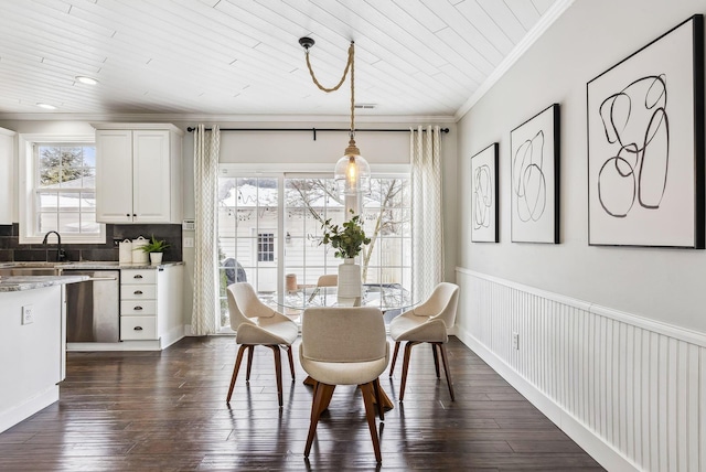 dining space with dark wood-style flooring, a healthy amount of sunlight, and crown molding