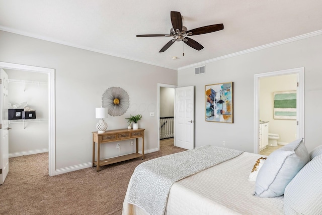 bedroom with carpet, crown molding, visible vents, a spacious closet, and baseboards