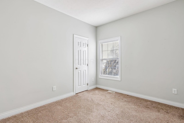 unfurnished room featuring carpet flooring and baseboards