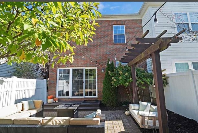 rear view of house featuring outdoor lounge area, brick siding, a fenced backyard, and a patio