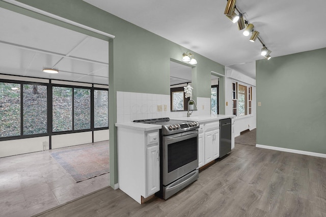 kitchen featuring light countertops, appliances with stainless steel finishes, a sink, and white cabinetry