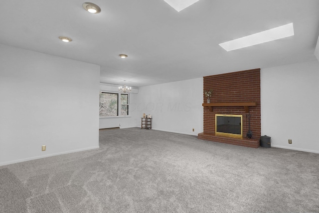 unfurnished living room with carpet floors, a skylight, a fireplace, and baseboards