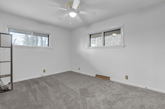 spare room with ceiling fan, carpet, visible vents, and baseboards