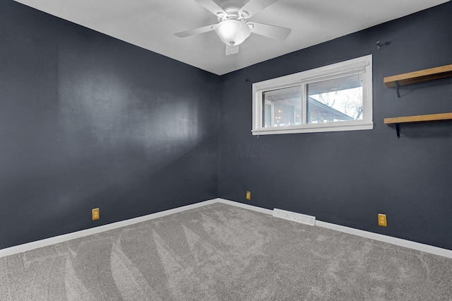 carpeted empty room with a ceiling fan, visible vents, and baseboards