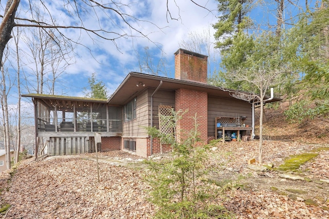 view of side of property with a sunroom and a chimney